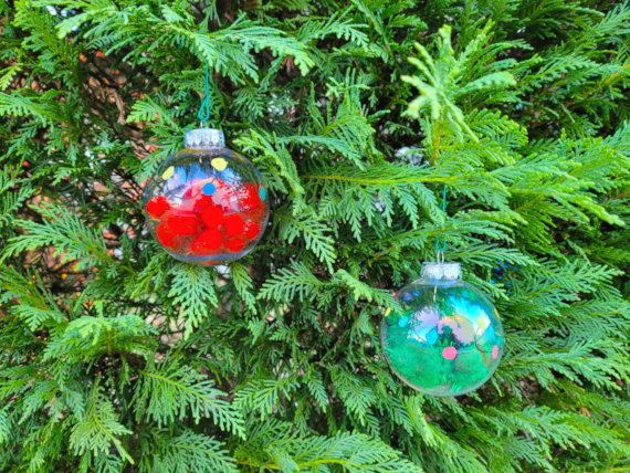 Two christmas ornaments on an evergreen tree