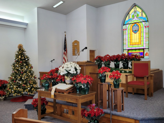 Front of Church Sanctuary decorated with a Christmas Tree and Poinsettias