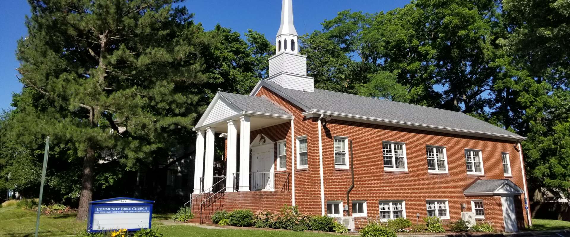 Side of church building on a sunny, early-summer Sunday morning
